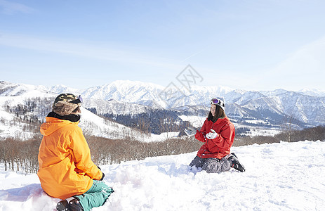滑雪场地上打雪仗的情侣图片