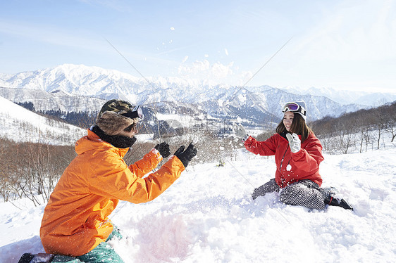 滑雪场地上打雪仗的情侣图片