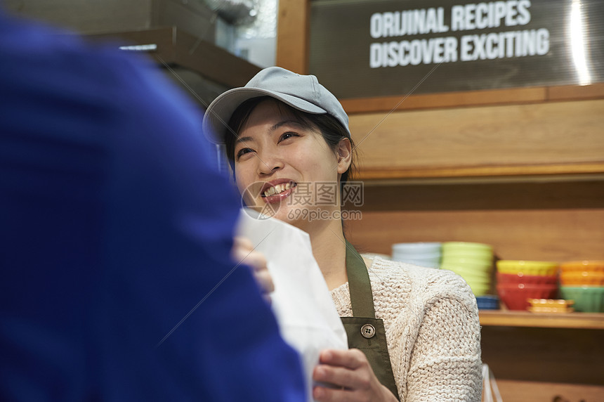 服务员将打包好的食物递给外卖员图片