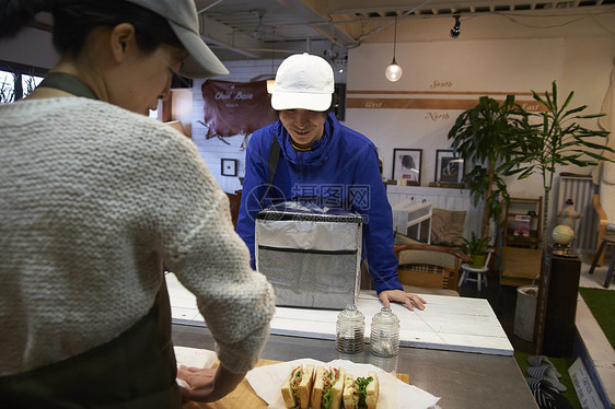 在等待餐厅服务员打包食物的外卖员图片