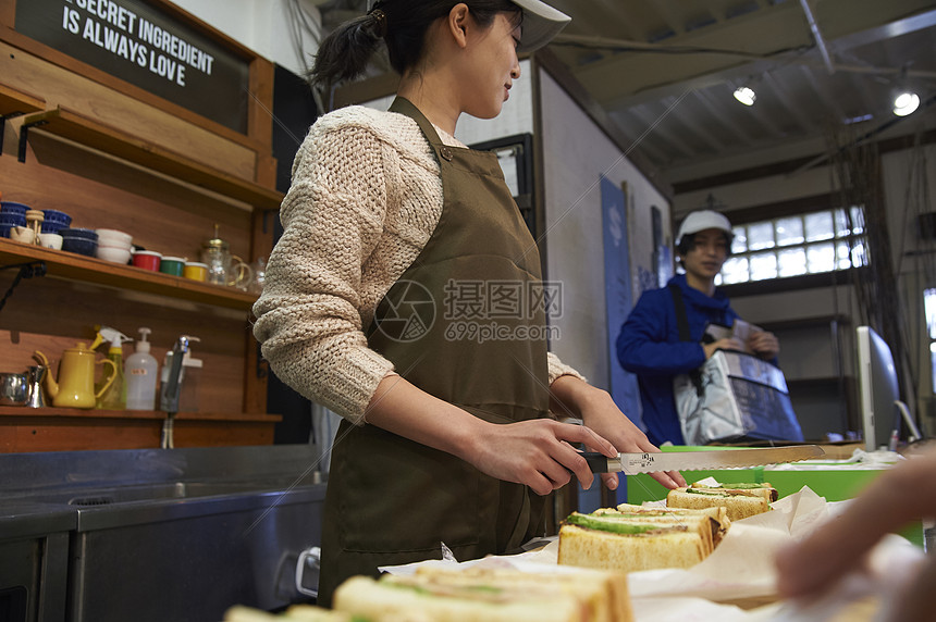 在等待餐厅服务员打包食物的外卖员图片