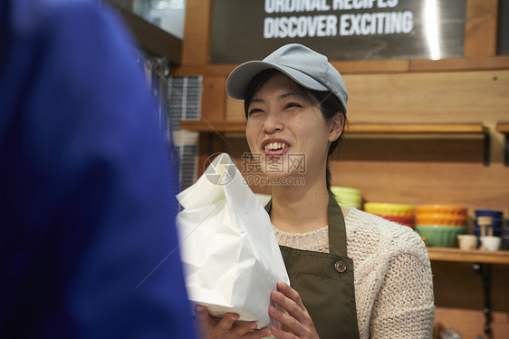 店员递包装好的外卖给配送员图片