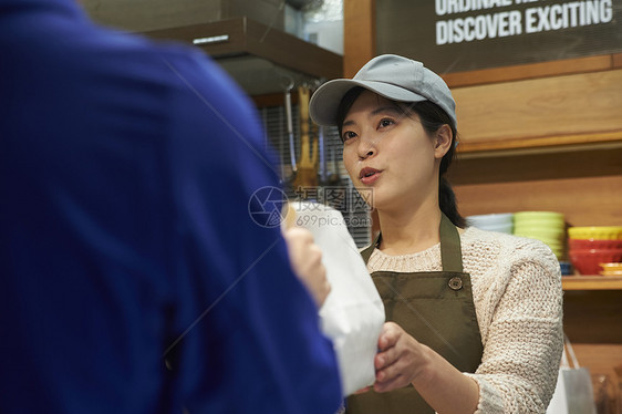 店员递包装好的外卖给配送员图片