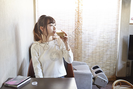 坐在休息室里喝咖啡的年轻女性图片