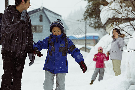 下雪天告别母亲背着书包上学的孩子们图片