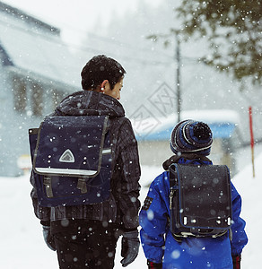 下雪天背着书包行走的学生背影图片