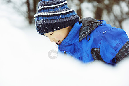 雪地里玩耍的小男孩图片