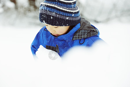 玩雪雪地里玩耍的小男孩背景