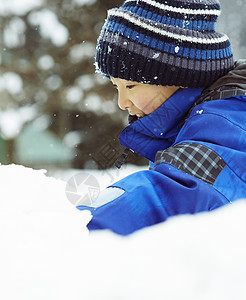 雪地里玩耍的小男孩图片