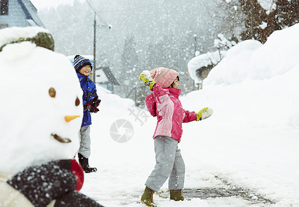 雪地里进行雪球大战的孩子们图片