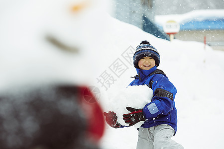 玩雪抱着一大块雪的小男孩背景