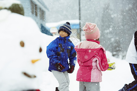 雪地里拿着雪球投掷的小女孩图片