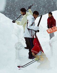 雪地里使用雪铲除雪的孩子们图片