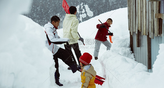 雪地里使用雪铲除雪的孩子们图片