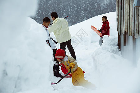 雪地里使用雪铲除雪的孩子们图片