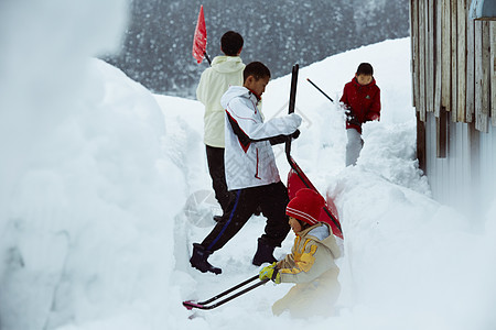 雪地里使用雪铲除雪的孩子们图片