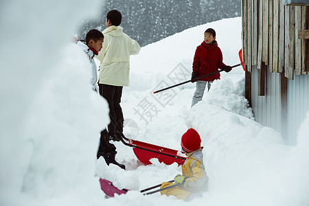 雪地里使用雪铲除雪的孩子们图片