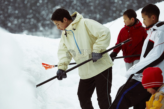 雪地里使用雪铲除雪的孩子们图片