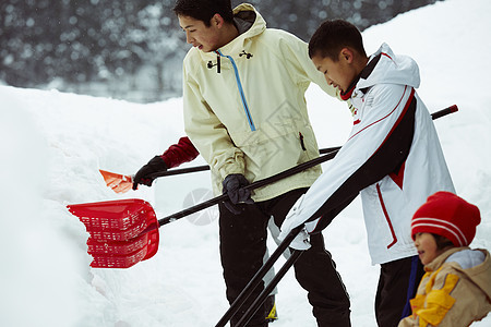 雪地里使用雪铲除雪的孩子们图片