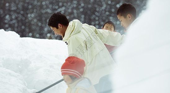 下雪天户外使用雪铲除雪的孩子们图片