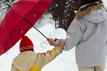下雪天撑着雨伞散步的母女图片