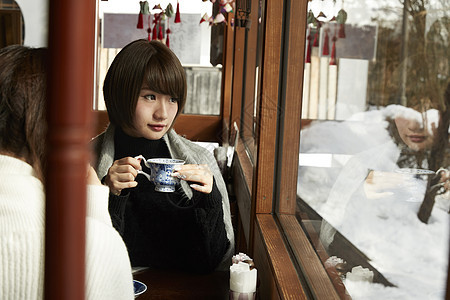咖啡厅喝着下午茶看向窗外的年轻女性图片