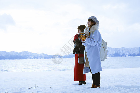 雪景区湖畔站在雪地里的少女们图片