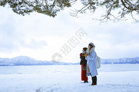 雪景区湖畔站在雪地里的少女们图片