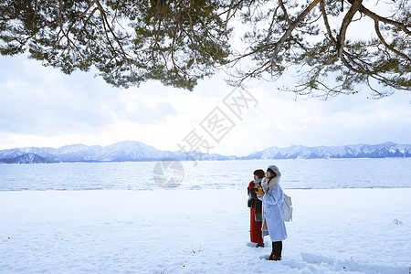 雪景区湖畔站在雪地里的少女们图片