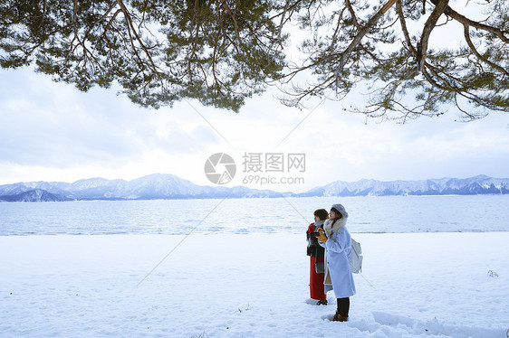 雪景区湖畔站在雪地里的少女们图片