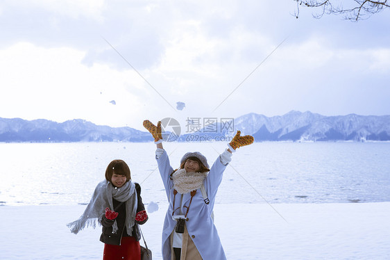 冬季旅程雪景区湖畔玩耍的少女图片