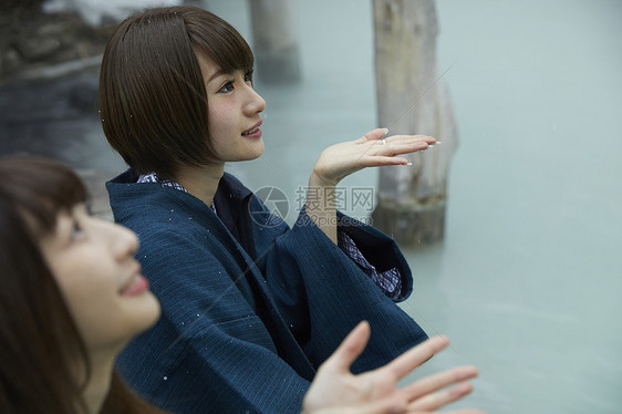 冬季雪天户外泡温泉的少女图片