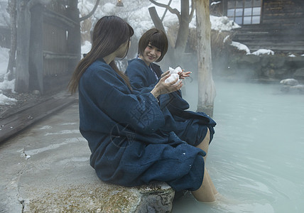 冬季雪天户外泡温泉的少女图片