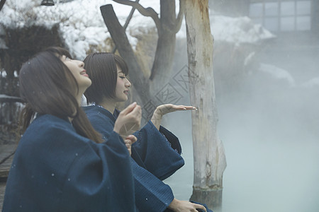 冬季雪天户外泡温泉的少女图片