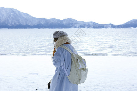 冬天在雪地里漫步背着背包的女孩图片