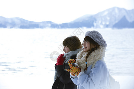 两个女孩在雪地里漫步图片