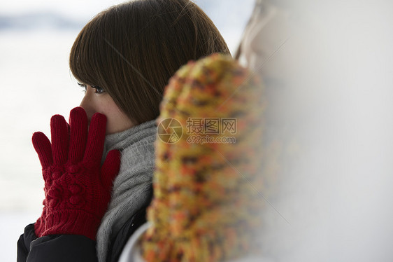 冬天雪地里女孩带着手套取暖图片