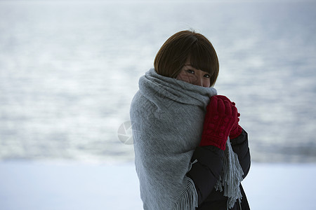 披着毯子的女性在寒冷冬天的雪地里图片