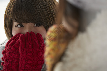 握着双手哈气取暖的少女图片素材