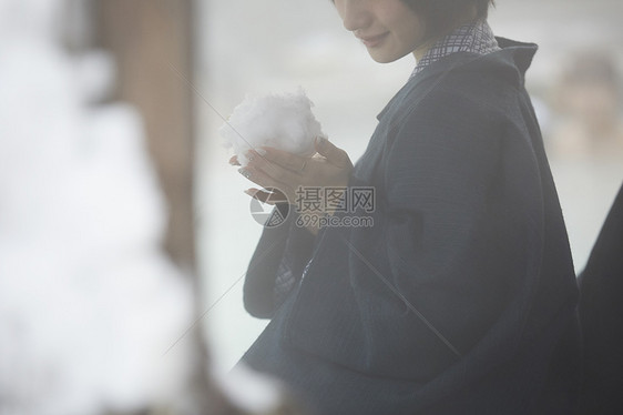 户外温泉捏着大雪球的女孩图片