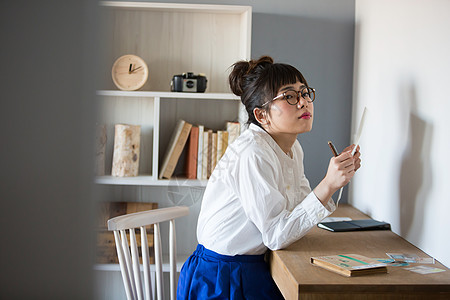 戴眼镜少女在书房拿着笔图片