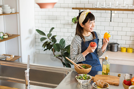 厨房里拿着食材的居家女性图片