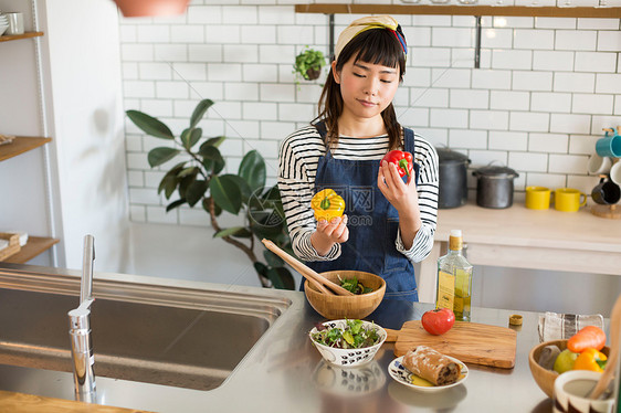 居家烹调食物的年轻女性图片