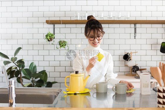 戴眼镜的女孩在厨房烧茶水图片