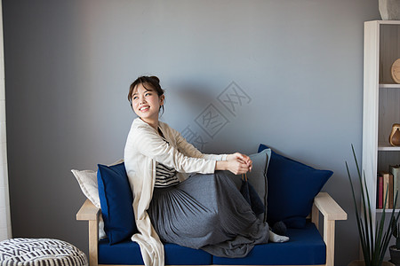 坐在沙发上放松微笑的居家女性图片素材