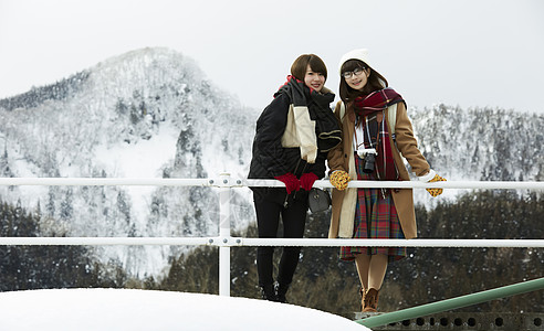 冬天女孩在旅途雪景驻地看前方图片