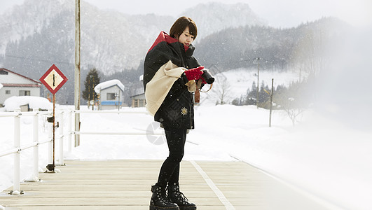 冬天女孩在风雪中拍摄图片