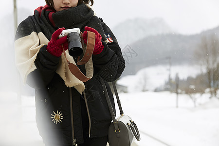冬天女孩在雪景中看照片图片