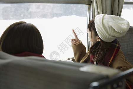 冬季两位女学生一起看向窗外的雪图片