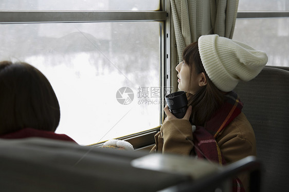 冬季两位女学生一起看向窗外的雪图片